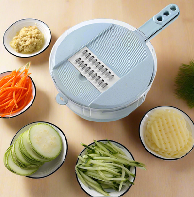 A ClickSmile 8-in-1 Mandoline Slicer Vegetable Cutter with a light blue handle sits on a light wooden surface, crafted from BPA-Free plastic and Food-Grade stainless steel. Surrounding it are small bowls, each containing various sliced or grated vegetables: shredded carrots, cucumbers, zucchini, and grated food.